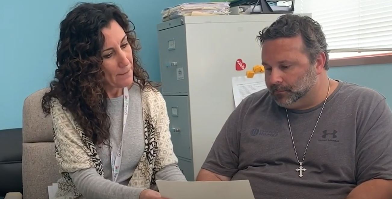 BAncroft Neuro Rehab clinician and patient looking over paperwork while sitting at a desk.