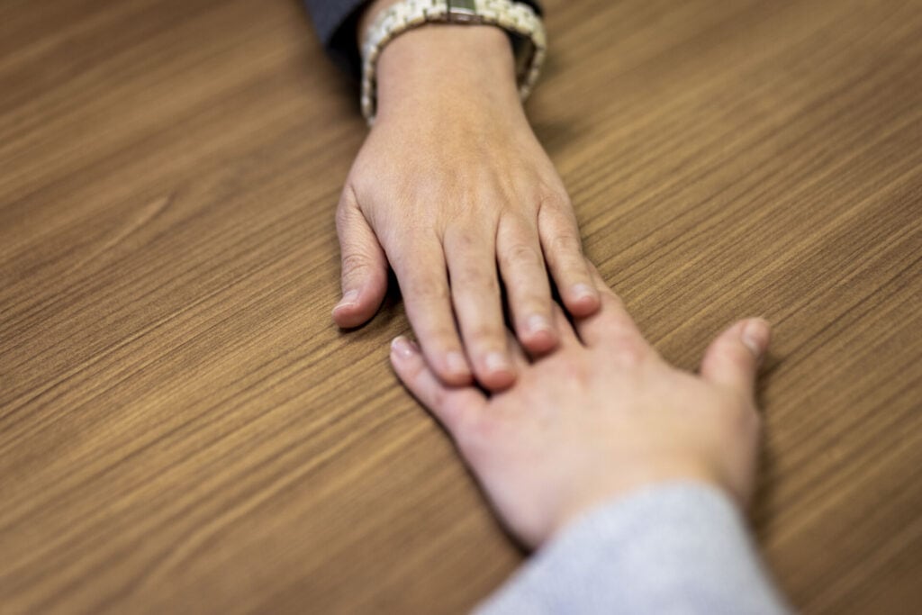 Two hands on top of each other in a psych session